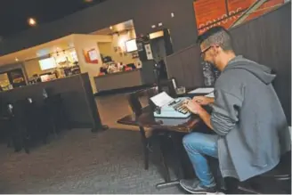  ?? Helen H. Richardson, The Denver Post ?? Carlos Flores on Wednesday uses a vintage typewriter to work on his screenplay at Henderson’'s Lounge inside the Denver Film Society’s Sie FilmCenter, 2510 E. Colfax Ave.
