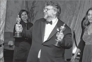  ?? AP PHOTO ?? Guillermo del Toro poses with his awards for best director and best picture for “The Shape of Water” at the Governors Ball after the Oscars on Sunday, March 4, 2018, at the Dolby Theatre in Los Angeles.