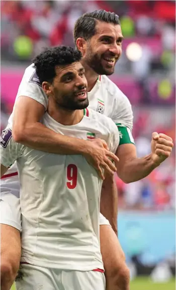 ?? ?? Iran's Karim Ansarifard, back, with teammate Mehdi Taremi celebrate at the end of the World Cup group B soccer match between Wales and Iran