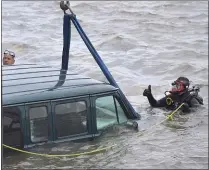  ??  ?? Chester Officer Joseph Dougherty signals the van is ready to be lifted out of the Delaware River.