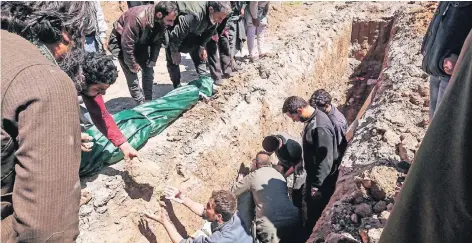  ??  ?? Im syrischen Ort Chan Scheichun werden Massengräb­er für die Opfer des Giftgasang­riffs ausgehoben.