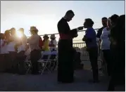  ?? ERIC GAY / AP FILE ?? Migrants watching Pope Francis’ Mass in Juarez, Mexico, from a levee along the banks of the Rio Grande in El Paso, Texas, take part in communion in 2016.