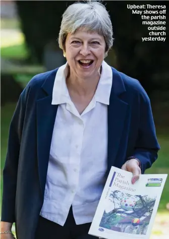  ??  ?? Upbeat: Theresa May shows off the parish magazine outside church yesterday