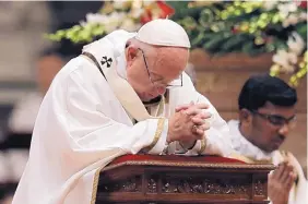  ?? ALESSANDRA TARANTINO/ASSOCIATED PRESS ?? Pope Francis kneels as he celebrates the Christmas Eve Mass in St. Peter’s Basilica at the Vatican, Saturday.