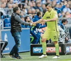  ??  ?? Trainer Manuel Baum klatscht Raúl Bobadilla nach seiner Auswechslu­ng auf Schalke ab. Ob der Stürmer gegen Freiburg spielen kann, ist fraglich.