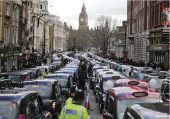  ?? FRANK AUGSTEIN/THE ASSOCIATED PRESS ?? Taxi drivers concerned with unfair competitio­n from Uber block the roads in central London on Wednesday.