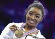  ?? GEERT VANDEN WIJNGAERT PHOTOS / AP ?? Simone Biles poses with her gold medal for the floor exercise during the apparatus finals at the Artistic Gymnastics World Championsh­ips in Antwerp, Belgium, on Oct. 8.