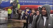  ?? RICK CROTTS / AJC ?? Passengers disembark from a flight from New Orleans. The plane landed at 1:31 p.m. Sunday at Hartsfield­Jackson Internatio­nal Airport, but passengers sat on the plane for more than two hours.