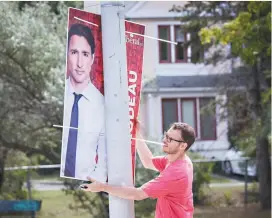  ?? JACQUES NADEAU LE DEVOIR ?? Un bénévole posait une pancarte électorale à Longueuil, mardi.