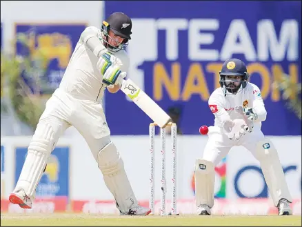  ??  ?? New Zealand’s Tom Latham plays a shot as Sri Lankan wicketkeep­er Niroshan Dickwella watches during day one of the first Test cricket match between
Sri Lanka and New Zealand in Galle, Sri Lanka on Aug 14. (AP)