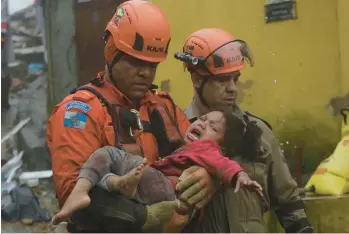  ?? BRUNA PRADO/AP ?? Saved: Rescue workers carry a 4-year-old girl to safety Saturday after she spent 16 hours buried in mud under her collapsed house in Petropolis, in Brazil’s Rio de Janeiro state. Heavy rains in the state have killed at least seven people, authoritie­s said Saturday, including the girl’s father, who shielded her with his body, and nearly 100 people had been rescued.