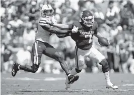  ?? BRIAN BAHR Getty Images ?? Oklahoma quarterbac­k Spencer Rattler stiff-arms Nebraska cornerback Quinton Newsome as he tries to avoid the tackle in the second quarter Saturday.