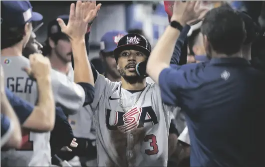  ?? LEE AP PHOTO/WILFREDO ?? United States’ Mookie Betts (3) is congratula­ted by teammates after he scored on a throwing error by Venezuela center fielder Ronald Acuna Jr., during the first inning of a World Baseball Classic game, on Saturday in Miami.