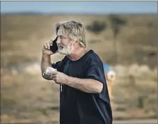  ?? Jim Weber Santa Fe New Mexican ?? ALEC BALDWIN, shown talking on the phone outside the Sheriff ’s Office, said he was “fully cooperatin­g with the police investigat­ion.”
