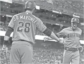  ??  ?? The Diamondbac­ks' A.J. Pollock, right, is congratula­ted by J.D. Martinez after scoring against the Giants during the fourth inning of Friday night’s game in San Francisco.