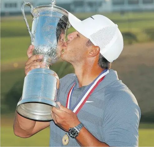  ?? CAROLYN KASTER / THE ASSOCIATED PRESS ?? Brooks Koepka kisses the champion’s trophy Sunday after winning the U.S. Open for the second straight year.