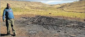  ??  ?? ASHES OF DREAMS: Zwelandile Khethwa stands next to the remains of a burnt initiation hut at Ntabasgogo village