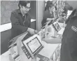  ??  ?? A cashier scans a barcode on a smartphone to complete a purchase at Amazon’s Books retail store in New York City.