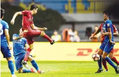  ?? - AFP photo ?? (FILES) This file photo taken on June 18, 2017 shows Shanghai SIPG’s Oscar (L) kicking the ball at a Guangzhou R&F player (R) in an incident that led to a brawl during their Chinese Super League match in Guangzhou, in China’s southern Guangdong...