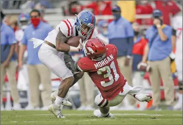  ?? Charlie Kaijo/NWA Democrat-Gazette ?? Going down: Arkansas linebacker Grant Morgan (31) tackles Ole Miss running back Jerrion Ealy (9) during their SEC clash at Donald W. Reynolds Razorback Stadium in Fayettevil­le during the 2020 season.
