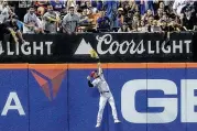  ?? BEBETO MATTHEWS / ASSOCIATED PRESS ?? Reds right fielder Albert Almora Jr. leaps into the wall to make a catch during the fifth inning Monday against the Mets in New York.