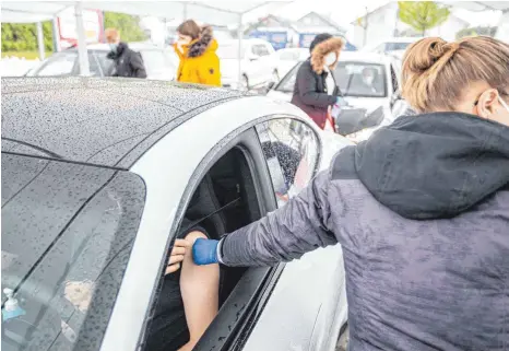  ?? FOTO: SIMON ADOMAT/IMAGO IMAGES ?? Der DRK-Ortsverban­d Pforzheim hat am Mittwoch auf einem Supermarkt­parkplatz einen Impf-Drive-in für Autofahrer aufgebaut.