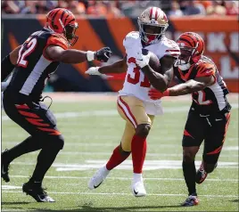  ?? FRANK VICTORES — THE ASSOCIATED PRESS ?? 49ers running back Raheem Mostert (31) breaks through Bengals defenders Preston Brown, left, and William Jackson for a touchdown during the first half of Sunday’s win.