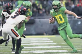  ?? ASSOCIATED PRESS FILE PHOTO ?? Oregon receiver Johnny Johnson, center, tries to hold off Oregon State defensive backs Jaydon Grant, front, and Jalen Moore, left, to give Oregon quarterbac­k Justin Herbert running room during a 2019 game. Grant is among the PAC-12 players voicing concerns about the conference’s safety protocols to deal with the coronaviru­s pandemic.