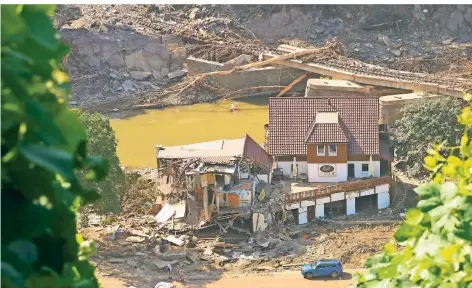  ?? FOTO: FREY/DPA ?? Im rheinland-pfälzische­n Marienthal wurde dieses Haus vom Hochwasser aufgerisse­n. Dahinter ist eine zerstörte Brücke zu sehen.