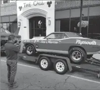  ??  ?? Jaime Munoz, of Cumberland, takes a photo of Ed Mongeon’s racing-modified19­71 Plymouth Barracuda.