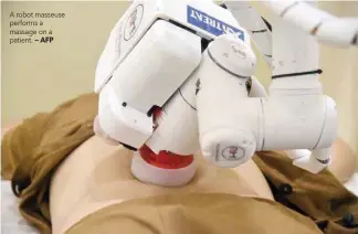  ?? — AFP ?? A robot masseuse performs a massage on a patient.