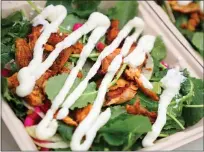  ??  ?? At Shawarmaji, a kale salad is served topped with spicemarin­ated chicken and toum, a garlic aioli.