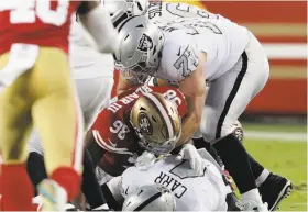  ?? Carlos Avila Gonzalez / The Chronicle ?? Derek Carr (4) is sacked by 49ers defensive end Ronald Blair II last Thursday at Levi’s Stadium. Carr was sacked seven times by the 49ers, so Raiders head coach Jon Gruden pulled him for his own safety.