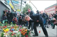  ?? AGENCE FRANCE-PRESSE ?? Hamburg’s mayor Olaf Scholz lays down flowers at a makeshift memorial in front of the supermarke­t.