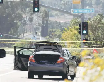 ??  ?? A car, allegedly used by the gunman, is pictured a few hundred feet from the Interstate 15 off-ramp north of San Diego, California. — Reuters photo