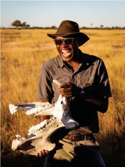  ??  ?? Above: Linkwasha Camp safari guide Lovemore Nowakhe explaining the power of a hippo’s bite with a jawbone found on a walk in Hwange National Park. Opposite: A Linkwasha Camp tent at night.