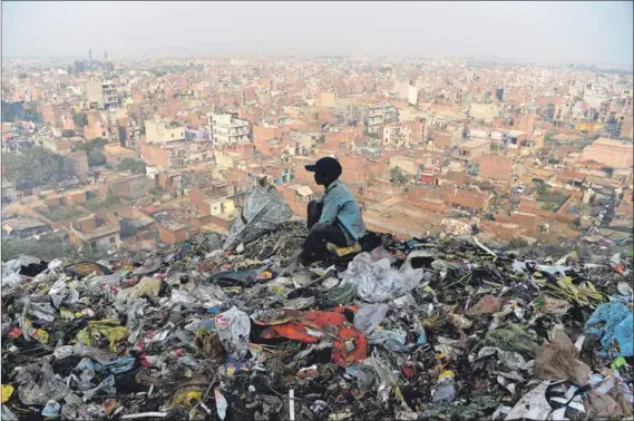  ?? Photo: Sajjad Hussain/afp ?? Rubbish theory: Resources are limited, so an economic model based on neverendin­g expansion (which fills up landfills such as this one in India) is irrational, the degrowth movement argues. Growth overuses the Earth’s biocapacit­y faster than its rate of regenerati­on.