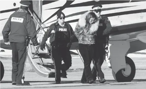  ?? PAUL CHIASSON / THE CANADIAN PRESS ?? RCMP officers on Monday escort a suspect in an alleged money-laundering network off an airplane in St-hubert, Que.