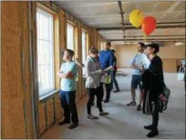  ??  ?? Tour guests looking out the windows of the last available space inside the Proctors building on Fourth Street, during the For Rent Event held Tuesday morning throughout downtown Troy.