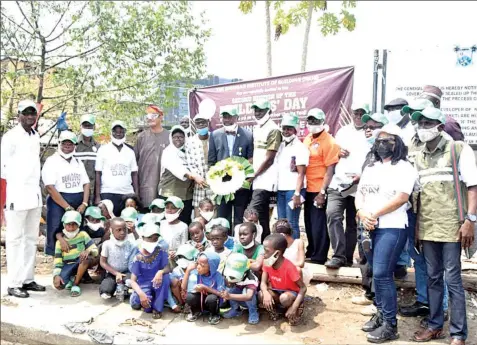  ??  ?? The President, Nigerian Institute of Building ( NIOB), Kunle Awobodu joined by leaders of the built environmen­t profession­al bodies laid wreath at the site of collapsed five- storey building on Massey Street, Ita- Faaji, Lagos Island on Builders' Day, with pupils that survived the collapse and still bearing the scars, sitting in remembranc­e of their mates that died in the collapsed building.