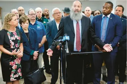  ?? AMY BETH BENNETT/ SOUTH FLORIDA SUN SENTINEL PHOTOS ?? Rabbi Pinny Andrusier speaks during a news conference at Chabad of Southwest Broward in Cooper City on Monday. Politician­s, including Congresswo­man Debbie Wasserman Schultz, left, Broward County Commission­er Nan Rich, second from left, and Broward County State Attorney Harold Pryor, right, and faith leaders were meeting for a roundtable discussion following harassment at Chabad of South Orlando last week and a call for a “day of hate” over the weekend.