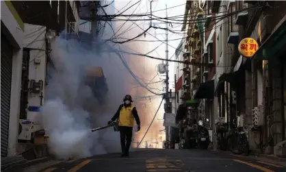  ?? ?? A South Korean official disinfecti­ng an alley to prevent the spread of coronaviru­s in 2020. Photograph: Chung Sung-Jun/Getty Images