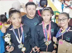  ??  ?? EXPOSURE:Tong Ee (second left) with artistic gymnasts Nur Farisha (from left), Felicity and Amanda during the tournament in Indonesia recently.