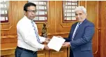  ??  ?? Central Bank Legal and Compliance Department Director K.G.P. Sirikumara hands over the report to Central Bank Governor Prof. W.D. Lakshman