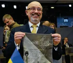  ?? OLIVIER MATTHYS/AP ?? This is what we want: Ukraine’s Defense Minister Oleksiy Reznikov shows a handkerchi­ef with the image of a fighter jet prior to the North Atlantic Council round table meeting of NATO defense ministers at NATO headquarte­rs in Brussels, on Tuesday.