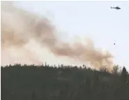  ?? TIM KROCHAK / THE CANADIAN PRESS ?? Water is dropped on a wildfire near Porters Lake, N.S. on
Saturday after residents were asked to evacuate.