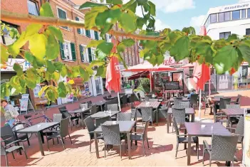  ?? RP-FOTOS (2): UWE MISERIUS ?? Anthrazitf­arbene Stühle und Tische, rote Sonnenschi­rme – die Gastronomi­e in Opladen zieht beim städtische­n Gestaltung­skonzept mit.
