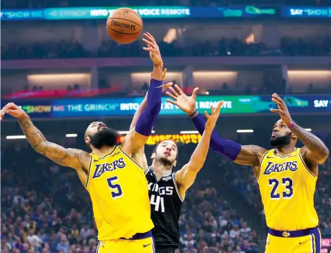  ??  ?? Los Angeles Lakers Tyson Chandler. left, Sacramento Kings Kosta Koufos, center, and Lakers' LeBron James, right, go for a rebound during the second half of an NBA basketball game in Sacramento, Calif. The Lakers won 101-86. ASSOCIATED PRESS