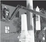  ?? GERALD HERBERT, AP ?? Workers dismantle the Liberty Place monument Monday in New Orleans. It was removed overnight in an attempt to avoid disruption from supporters who want the monuments to stay.