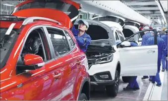  ?? MA JIAN / FOR CHINA DAILY ?? Employees of SAIC Motor Corp Ltd work on the company’s production line in Zhengzhou, Henan province.